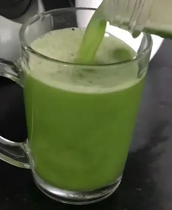 Glass of fresh moringa juice with moringa leaves